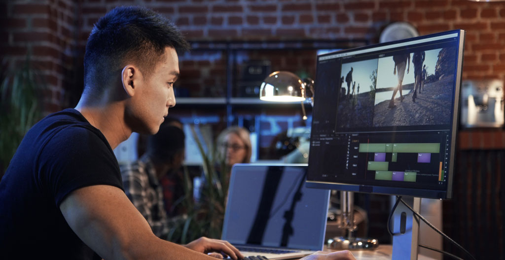 Bureau de travail vu de dessus avec ordinateur portable, tasse de café et carnet, mains posées sur le clavier